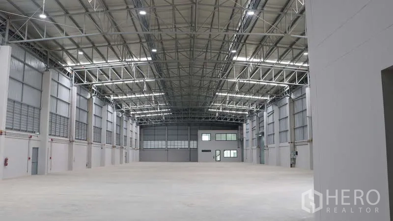 Warehouse for rent in Sam Phran, Nakhon Pathom - Raised loading dock edge with safety marking beside a glass office entry.