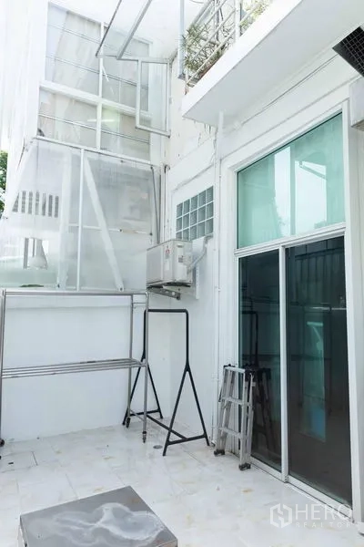 Townhouse for sale - Service balcony with sliding glass door, AC unit and drying area.