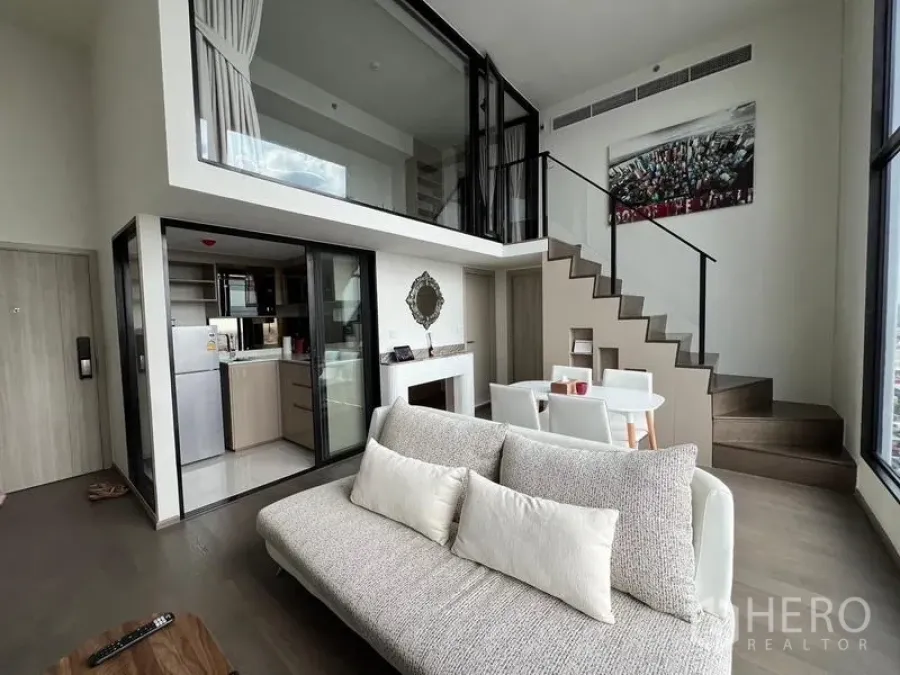 公寓 出租在Ratchathewi, Bangkok - 复式客厅另一角度，带楼梯与封闭式厨房。