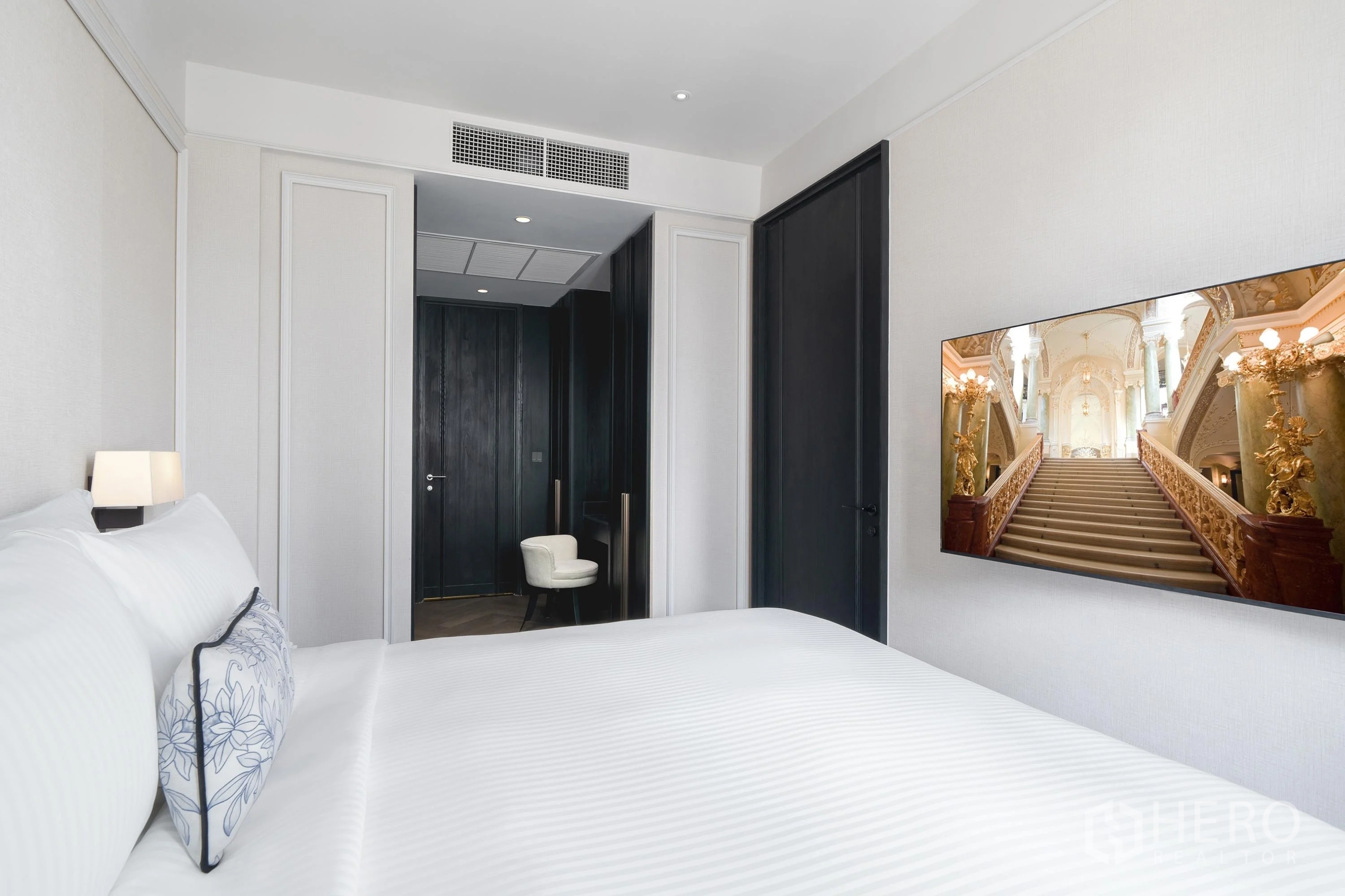 คอนโด for rent in Khlong Toei, Bangkok - มุมห้องนอนมองไปยังประตูไม้สีเข้มและโต๊ะเครื่องแป้งบิลท์อิน
