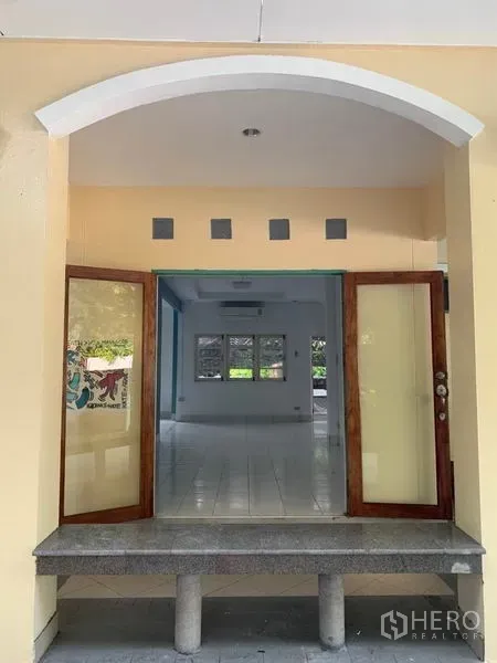 独立式住宅 出租在Khlong Toei, Bangkok - 拱形入口，木框双开门通向明亮客厅。