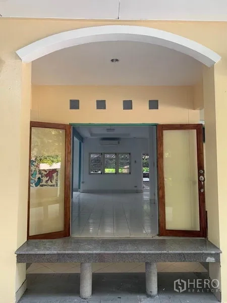 独立式住宅 出租在Khlong Toei, Bangkok - 拱形入口，木框双开门通向明亮客厅。