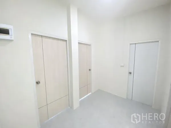 Warehouse for rent in Mueang Pathum Thani, Pathum Thani - Clean hallway in the office zone with three internal doors and white walls.