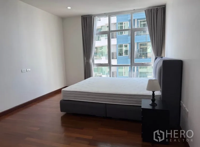 公寓 for rent in Pathum Wan, Bangkok - 采光明亮的卧室，落地大窗、窗帘与双人床，木地板。