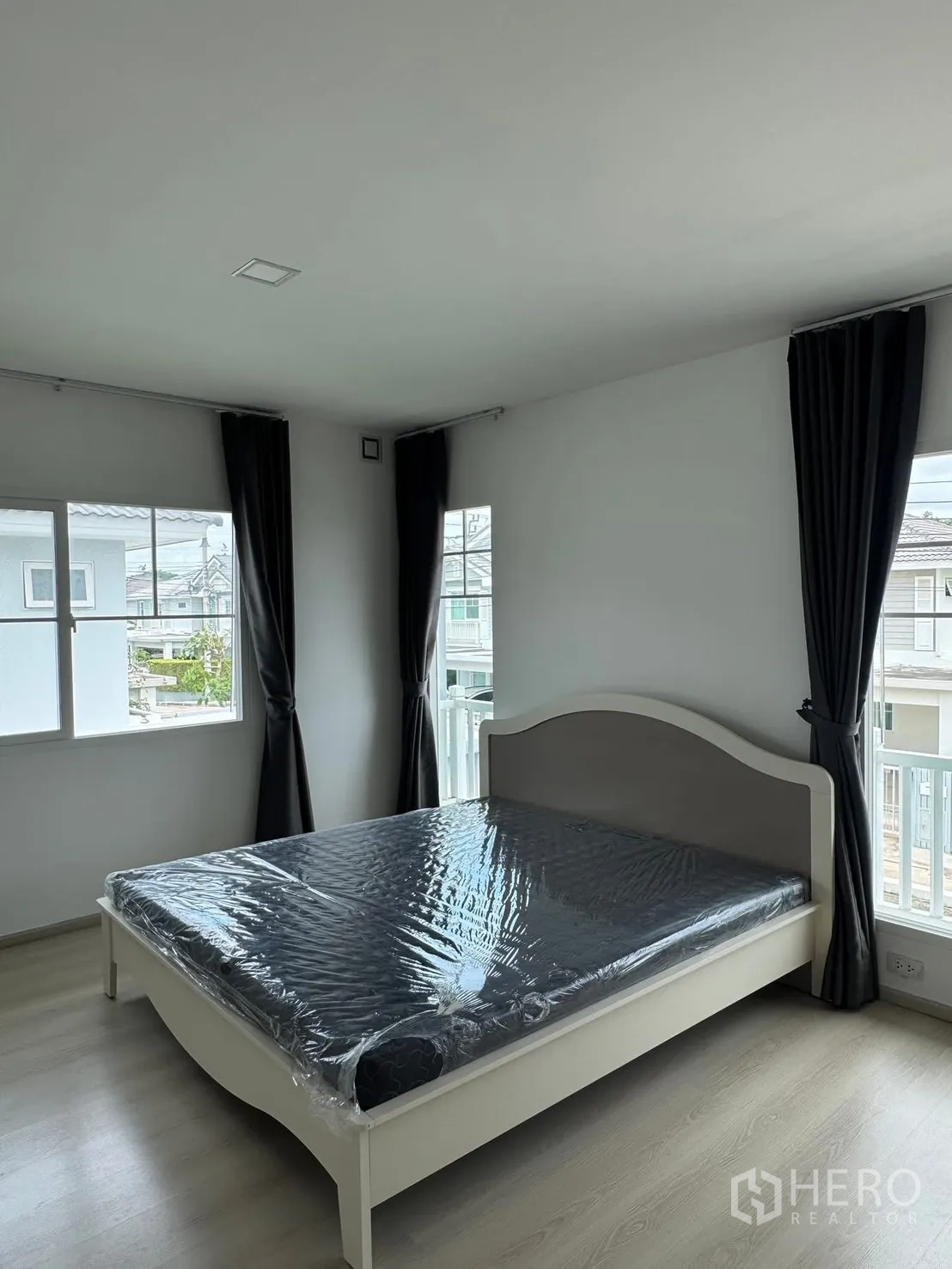Detached House for rent in Bang Phli, Samut Prakan - Bedroom with white bedframe, large windows, and dark curtains.