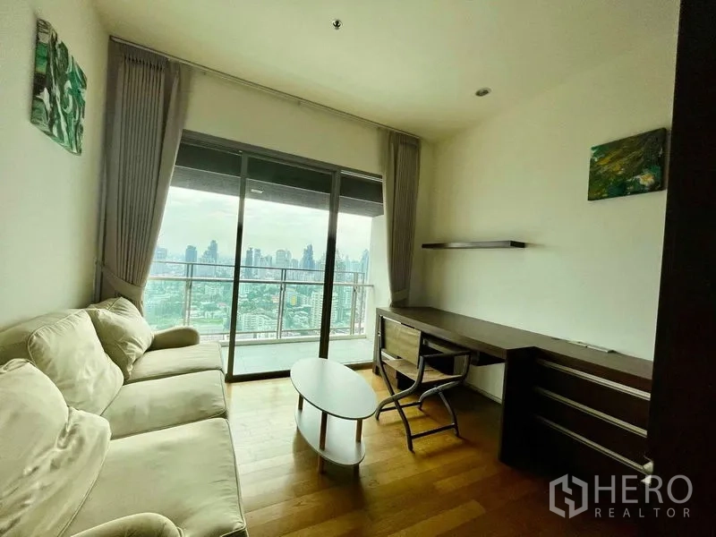 公寓 出租在Watthana, Bangkok - 书房/小客厅，沙发、书桌与面向天际线的阳台。