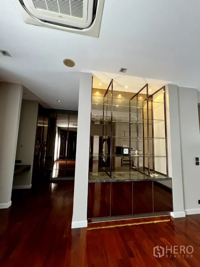 Detached House for rent or sale in Prawet, Bangkok - Hallway area showcasing an illuminated glass display cabinet and wood floors.