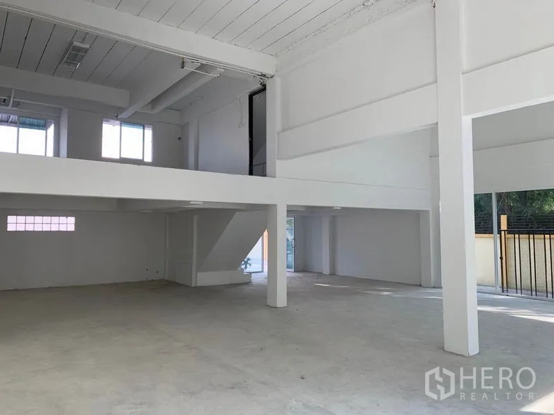 Office Space for rent in Huai Khwang, Bangkok - High-ceiling ground floor with mezzanine, staircase and wide entry next to the gate.