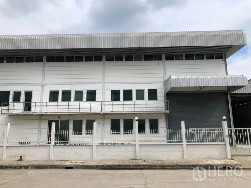工厂 出租在Lam Luk Ka, Pathum Thani - 建筑正面，带阳台、整排窗户与带雨棚的装卸口卷帘门