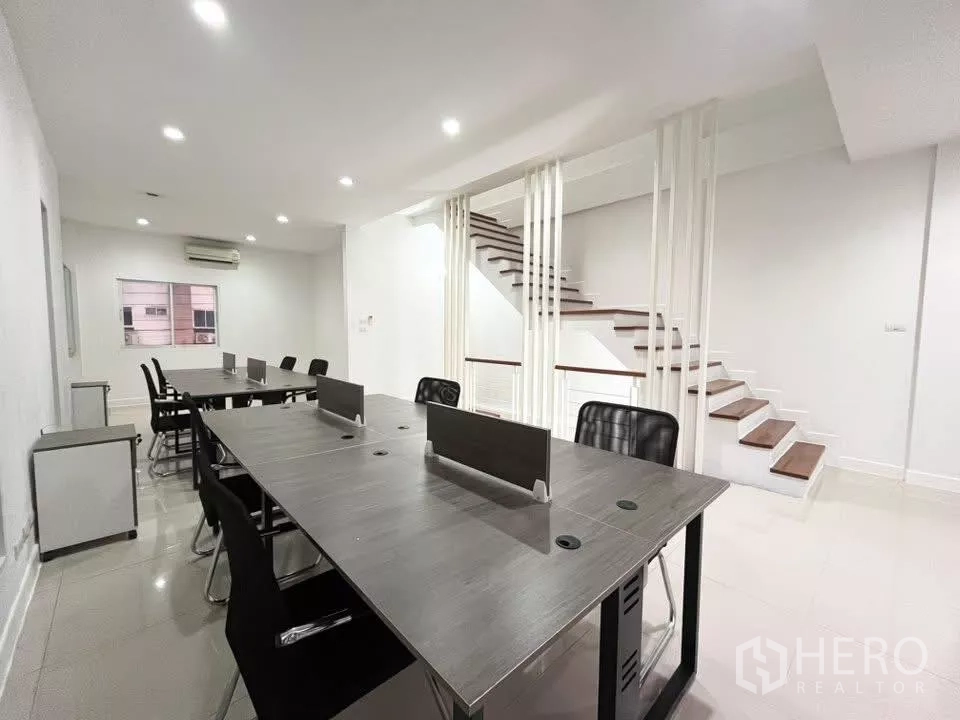 Home Office for rent in Bueng Kum, Bangkok - Open-plan workspace with long desks, chairs and a feature staircase.