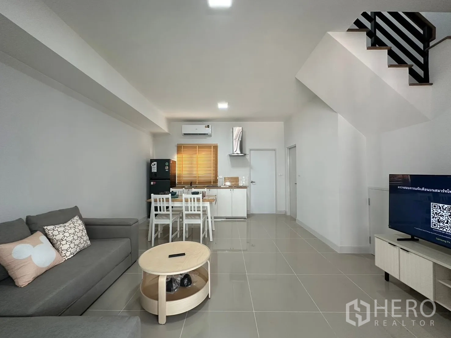 Townhouse for rent in Bang Phli, Samut Prakan - Wide view of the airy living area with TV console, staircase, and compact kitchen.