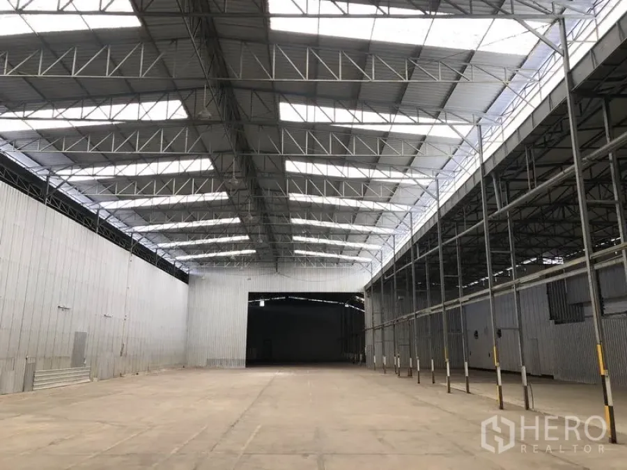 คลังสินค้า ให้เช่าในPak Kret, Nonthaburi - มองไปยังช่องโหลดขนาดใหญ่ ใต้หลังคาสูงมีสกายไลต์ และแถวเสาด้านข้าง