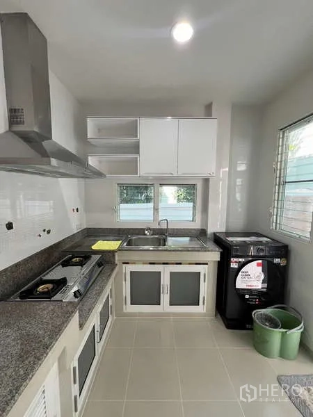 Detached House for rent in Bang Kapi, Bangkok - Thai kitchen with granite counters, gas hob, range hood, sink and window light.