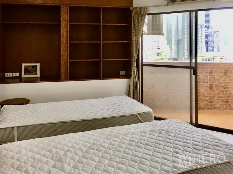 公寓 出租在Watthana, Bangkok - 次卧配双床，内置书架，推拉门通往可观景的阳台。