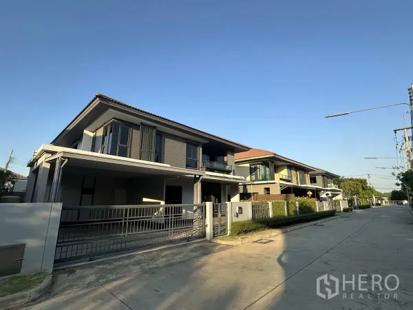 Detached House for rent or sale in Lam Luk Ka, Pathum Thani - Quiet estate street with contemporary homes and wide concrete roadway.
