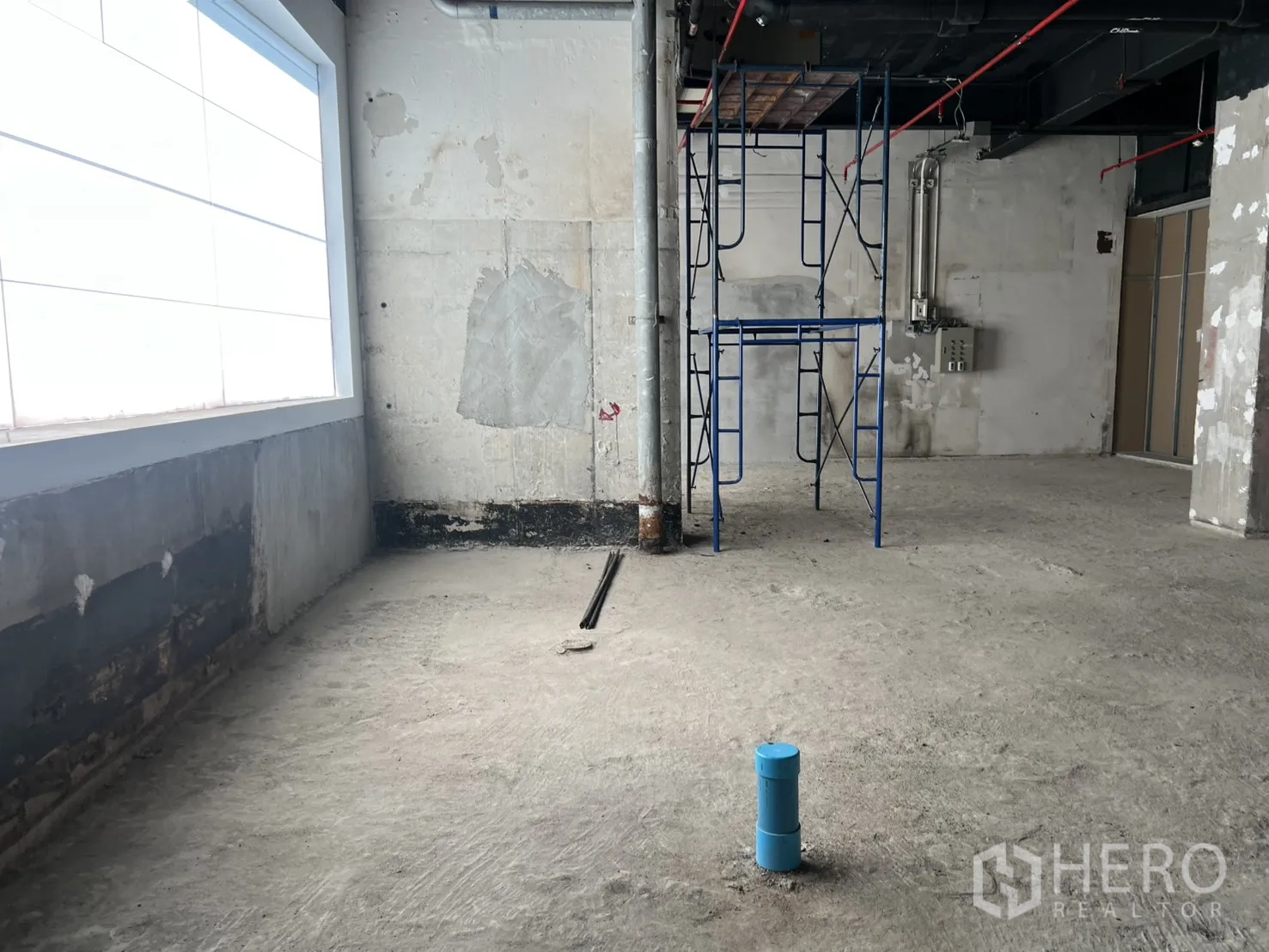 Retail Space for rent in Pathum Wan, Bangkok - Corner area with scaffolding beside a frosted window in shell condition.