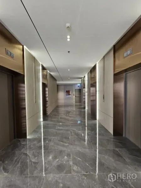 Office Space for rent in Bang Rak, Bangkok - Modern elevator lobby with multiple lifts, marble floors, and accent lighting.