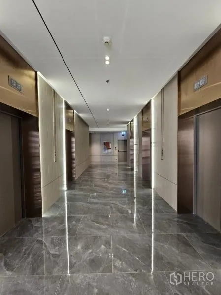 Office Space for rent in Bang Rak, Bangkok - Modern elevator lobby with multiple lifts, marble floors, and accent lighting.
