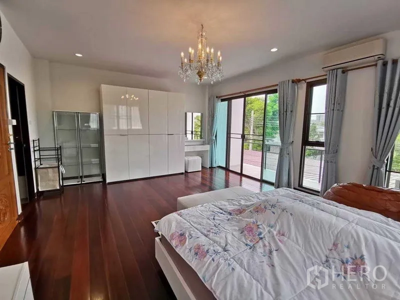บ้าน ให้เช่าในPrawet, Bangkok - ห้องนอนใหญ่เปิดออกสู่ระเบียงด้วยประตูกระจกบานเลื่อน มีโคมระย้าและตู้สีขาว
