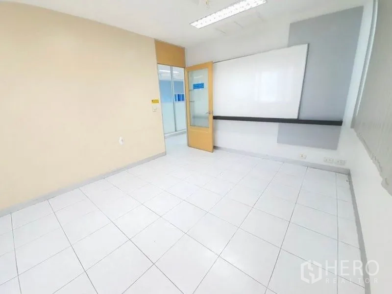 Office Space for rent in Bang Na, Bangkok - Small meeting room with a wall-mounted whiteboard, beige door and tiled flooring.