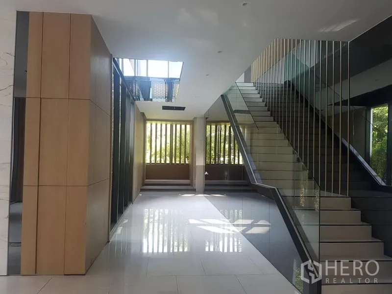 Retail Space for rent in Khlong Toei, Bangkok - Bright lobby with glossy tile floors and a mirrored staircase leading to upper levels.