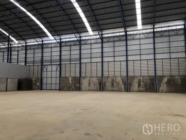 Factory for rent in Lat Lum Kaeo, Pathum Thani - Spacious factory interior with high arched steel roof and skylight panels over a concrete floor.