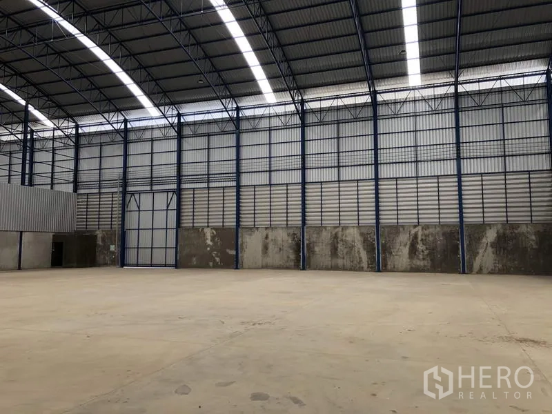 Factory for rent in Lat Lum Kaeo, Pathum Thani - Spacious factory interior with high arched steel roof and skylight panels over a concrete floor.