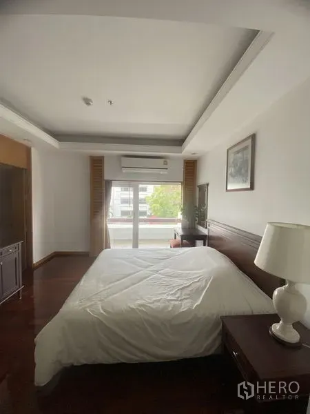 公寓 出租 - 主卧铺木地板，床旁边柜，推拉门连接阳台，采光充足。
