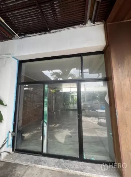 零售空间 出租 - 黑色铝框方形玻璃门面，通向采光良好的庭院。