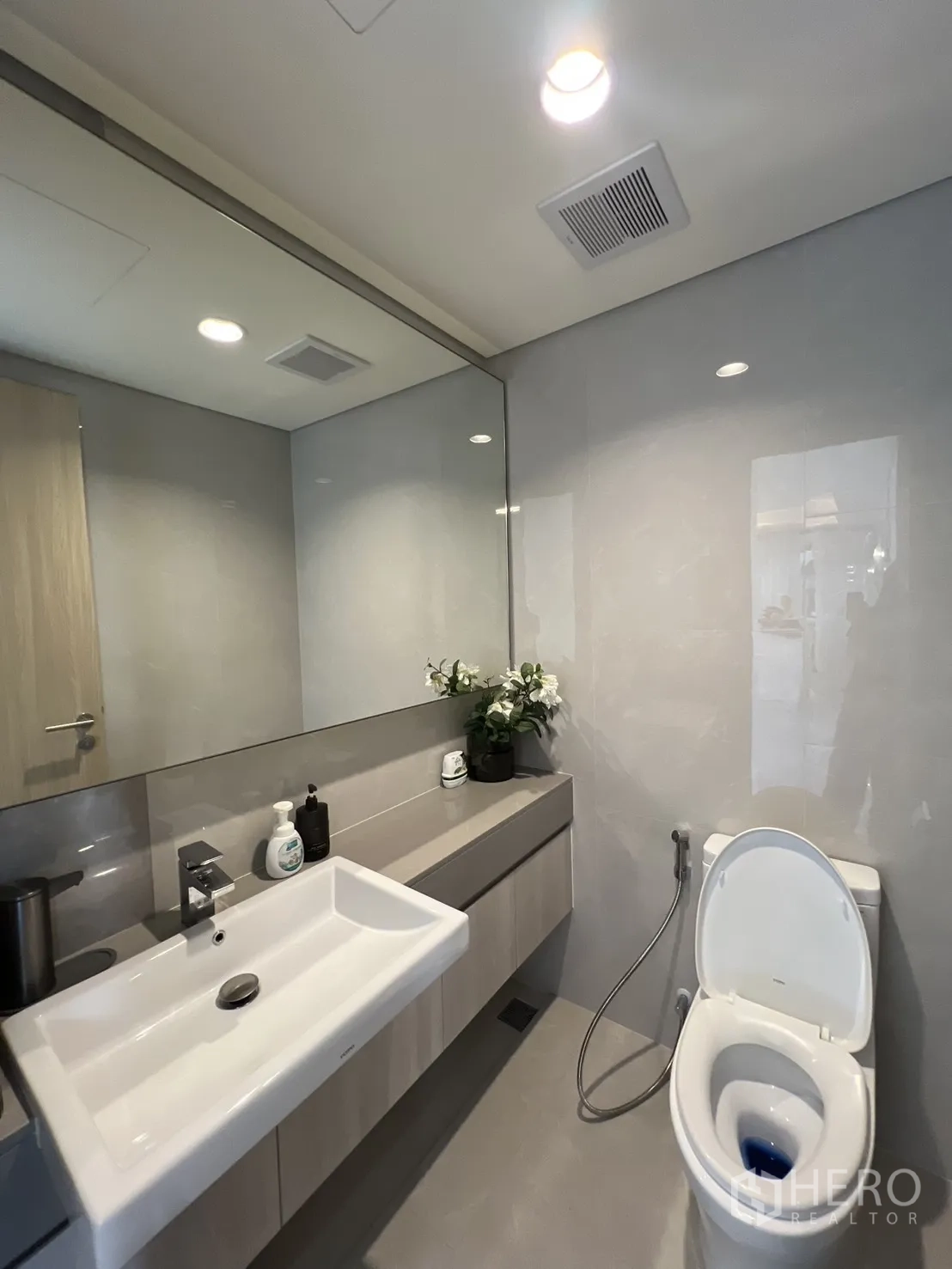 Semi-detached House for sale in Yan Nawa, Bangkok - Modern powder room with large mirror, vanity, and toilet.