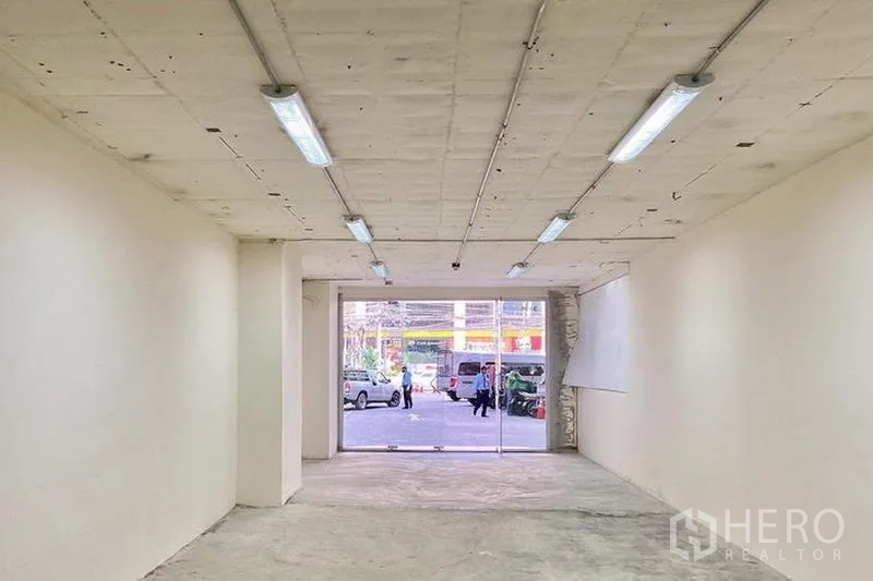 Retail Space for rent in Watthana, Bangkok - Bright shell space facing a glass entrance with street view and parking outside.