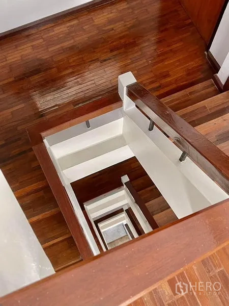 Home Office for rent in Khlong Toei, Bangkok - View down hardwood staircase and white-walled stairwell core.