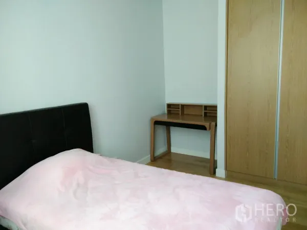 Condominium for rent in Khlong Toei, Bangkok - Guest bedroom with single bed, study desk, and sliding wood closet.