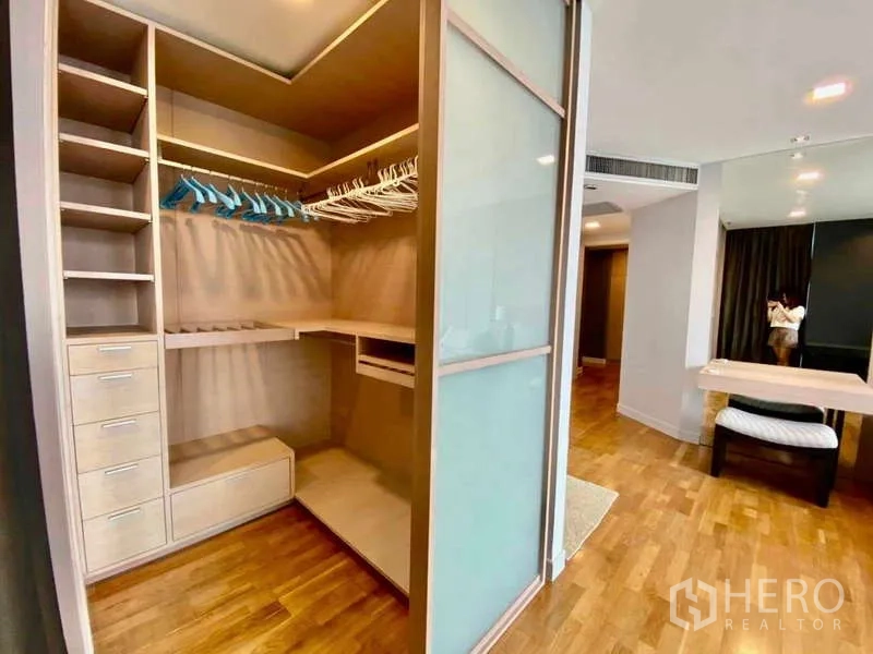 Condominium for rent or sale in Sathon, Bangkok - Walk-in closet with shelving, drawers, and sliding glass doors.