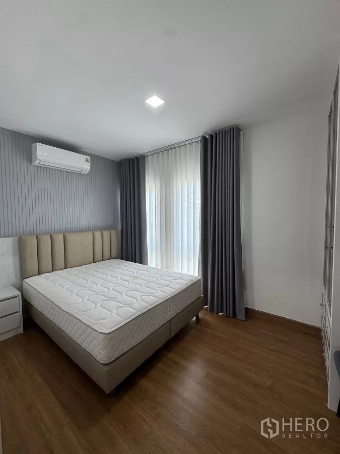 Detached House for rent in Bang Phli, Samut Prakan - Second bedroom with upholstered headboard, air-conditioning and full-height curtains.