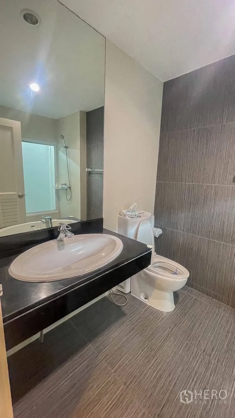 บ้านเดี่ยว for rent or sale in Saphan Sung, Bangkok - ห้องน้ำพร้อมกระจกบานใหญ่ อ่างล้างหน้า โถสุขภัณฑ์ และมุมอาบน้ำ.