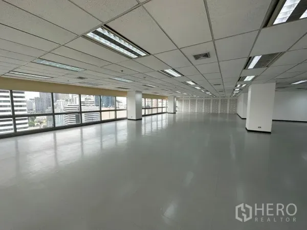 办公空间 出租 - 狭长矩形办公楼层，城市景观，瓷砖地面与周边玻璃窗。