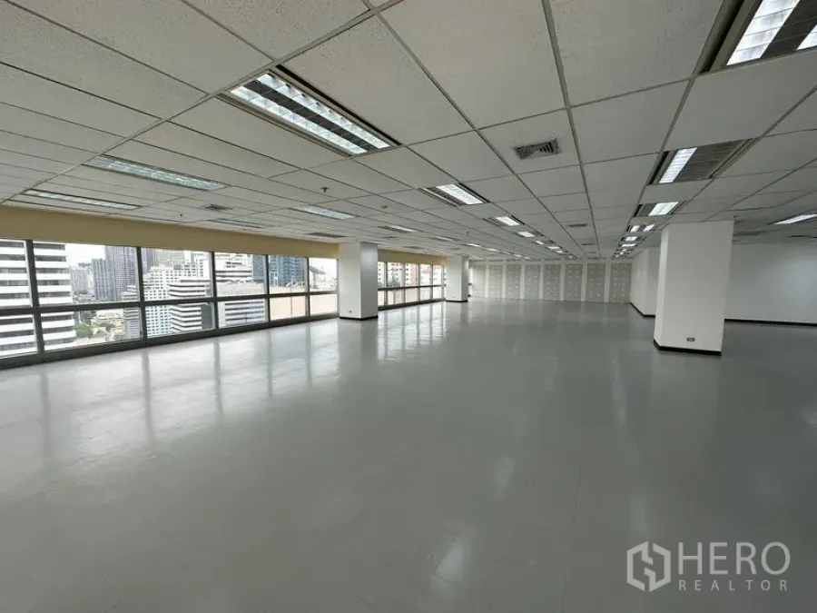 办公空间 出租 - 狭长矩形办公楼层，城市景观，瓷砖地面与周边玻璃窗。
