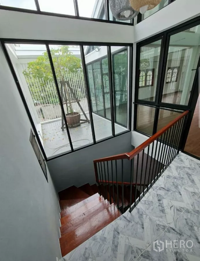 带办公室的家 出租在Lat Phrao, Bangkok - 楼梯间全高玻璃围合，可眺望室内树景小庭院。