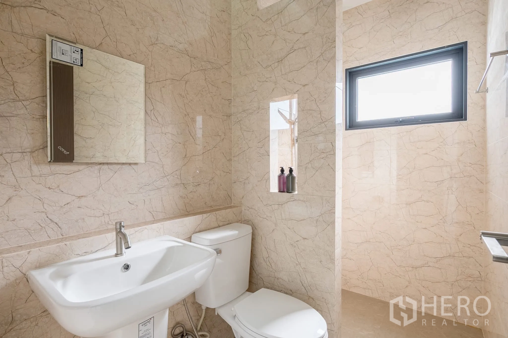 Home Office for rent in Khlong Toei, Bangkok - Ensuite bathroom with beige marble tiles, sink, toilet and shower area with window.