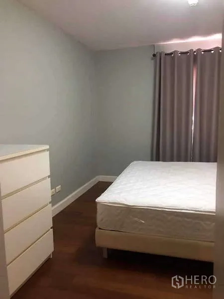 Condominium for sale in Yan Nawa, Bangkok - Compact bedroom with white dresser, queen bed and blackout curtains.