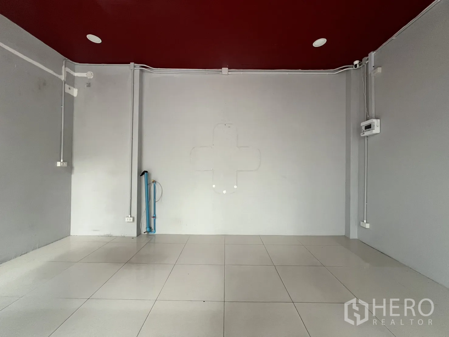 พื้นที่ขายของ for rent in Watthana, Bangkok - โซนขายพื้นกระเบื้องสีขาวโล่ง ฝ้าเพดานสีแดงเลือดหมู พร้อมปลั๊กไฟและท่อเดินสาย