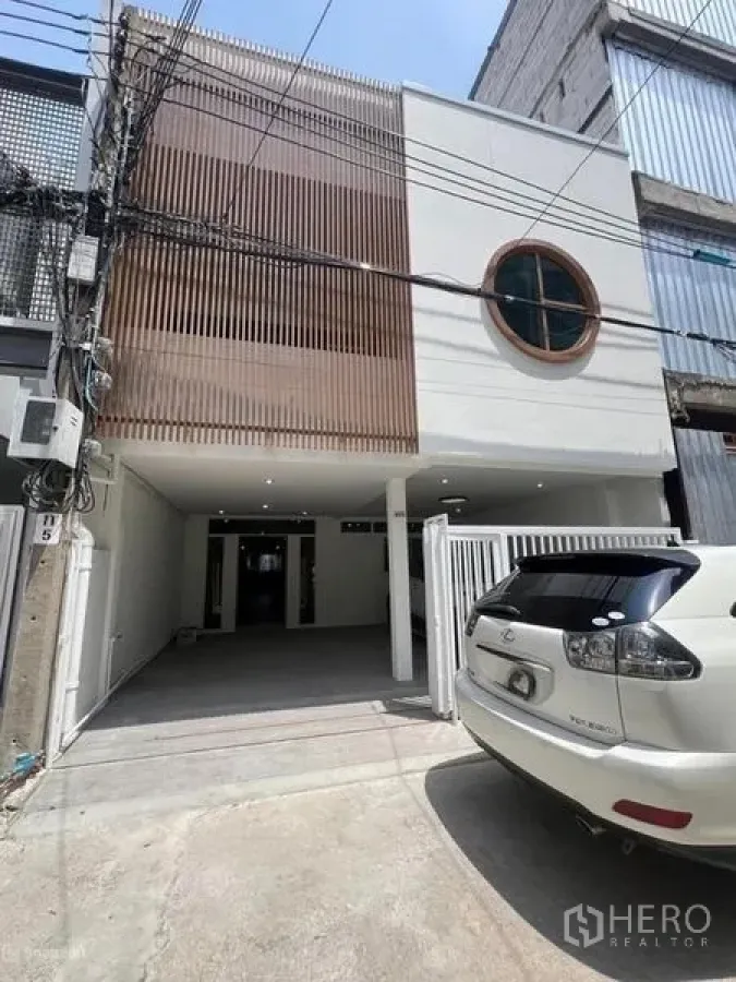 联排别墅 出租在Khlong Toei, Bangkok - 联排别墅正立面，带栅栏停车位与圆窗细节。