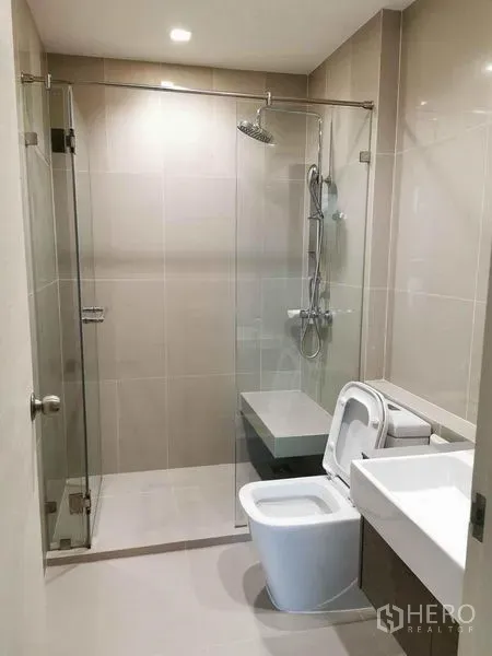 公寓 出租或出售在Din Daeng, Bangkok - 现代浴室，玻璃淋浴间与坐便器。