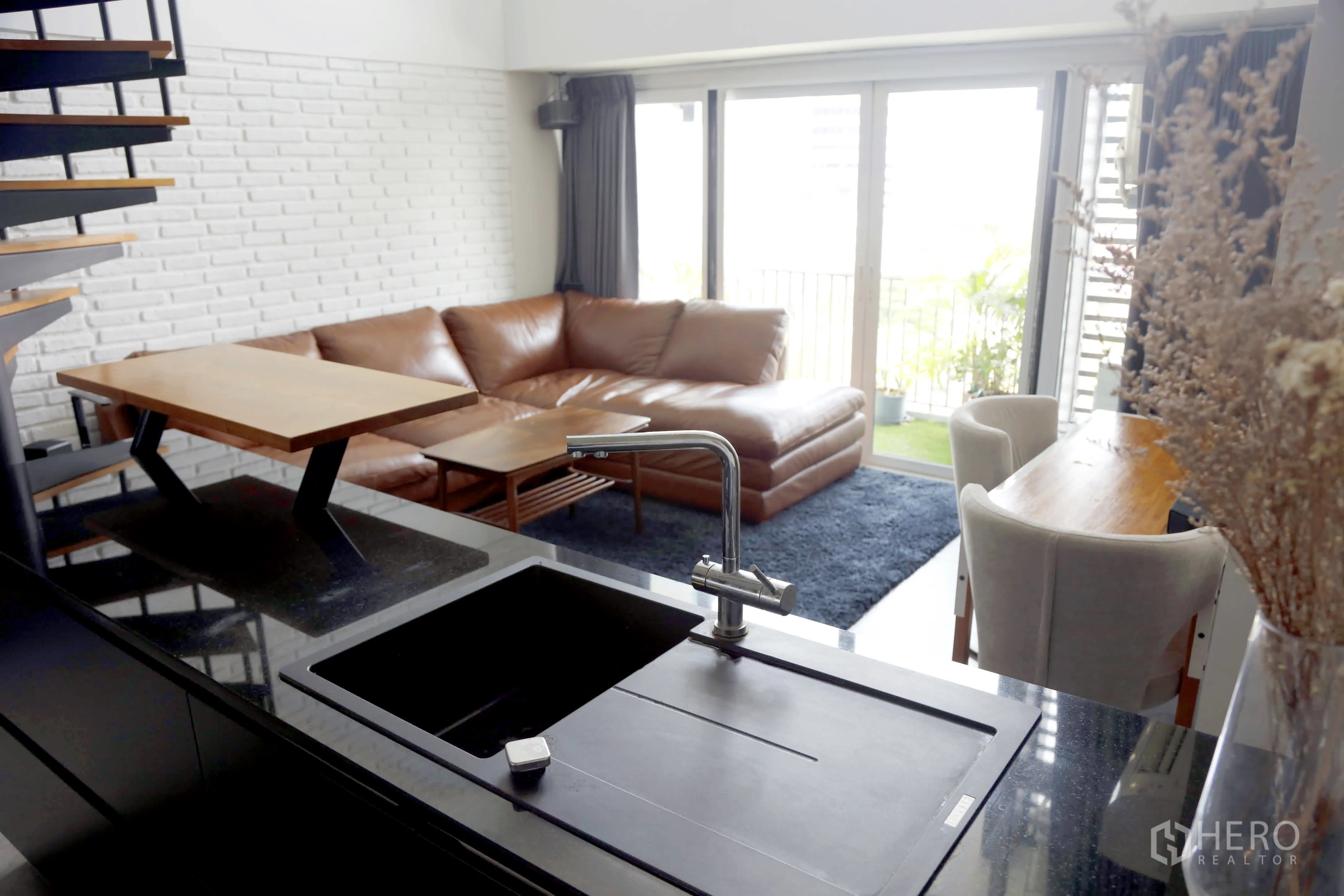 คอนโด for rent in Watthana, Bangkok - เคาน์เตอร์อ่างล้างจานครัวมองเห็นห้องนั่งเล่น ชุดทานอาหาร และระเบียง