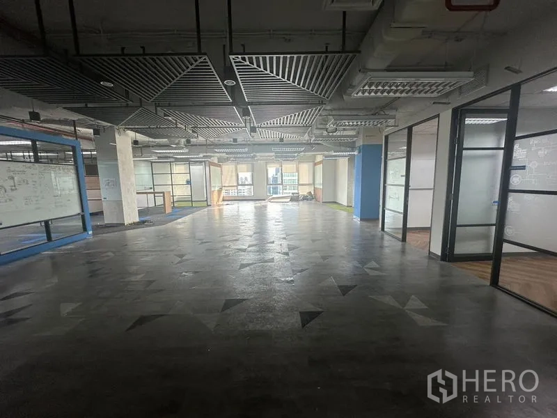 办公空间 出租在Bang Rak, Bangkok - 开放办公区，格栅吊顶，右侧玻璃房与抛光地面。