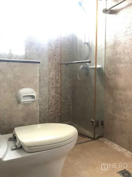 独立式住宅 出售在Lat Krabang, Bangkok - 卫生间配玻璃淋浴房与米色纹理瓷砖。