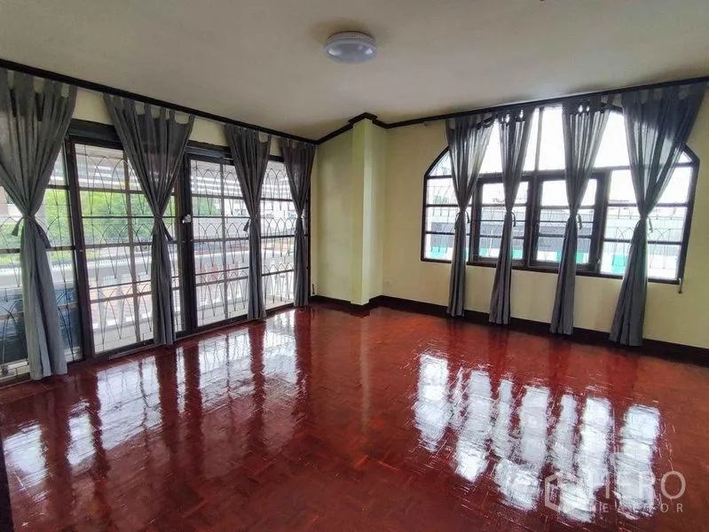 独立式住宅 出租在Khlong Toei, Bangkok - 二层采光充足的多功能房，窗帘与多扇窗，通往阳台，亮面木地板。