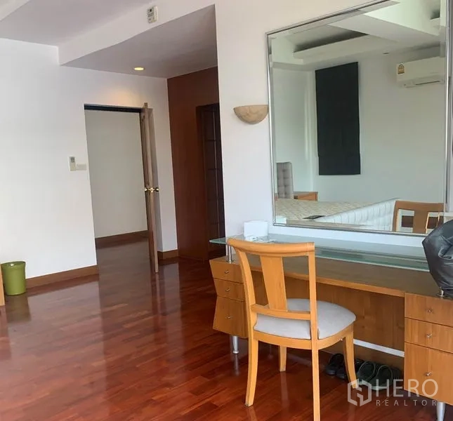 Detached House for rent in Din Daeng, Bangkok - Bedroom with hardwood floors, vanity desk and large wall mirror.