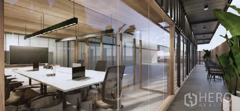 Warehouse for rent in Bueng Kum, Bangkok - Glass-partitioned office with a long worktable, task chairs, and a corridor along the side.